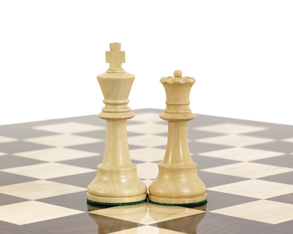 Hand carved boxwood Staunton king and queen chess pieces on a black and white chessboard