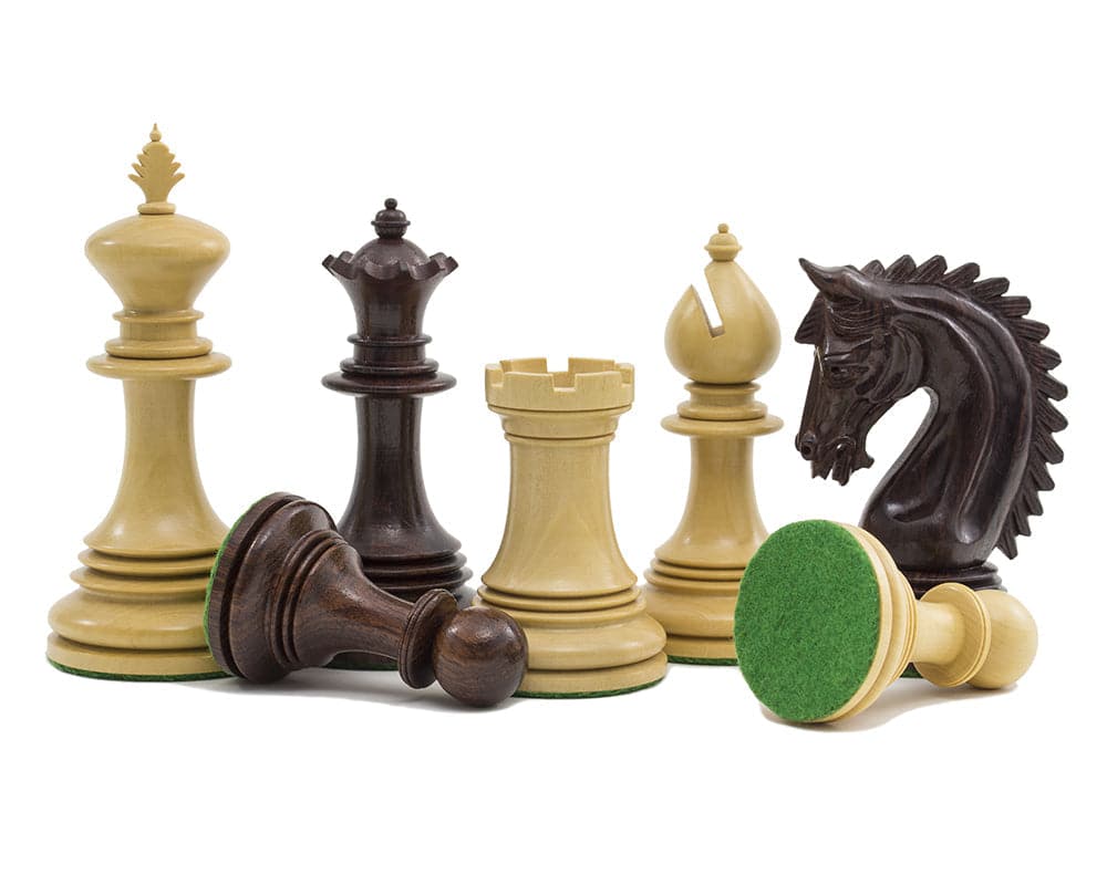 The Lemington Rosewood Chessmen 4.25 inch pieces showing ornate detailing, including the 4.25 inch king and knight with green billiard cloth bases.