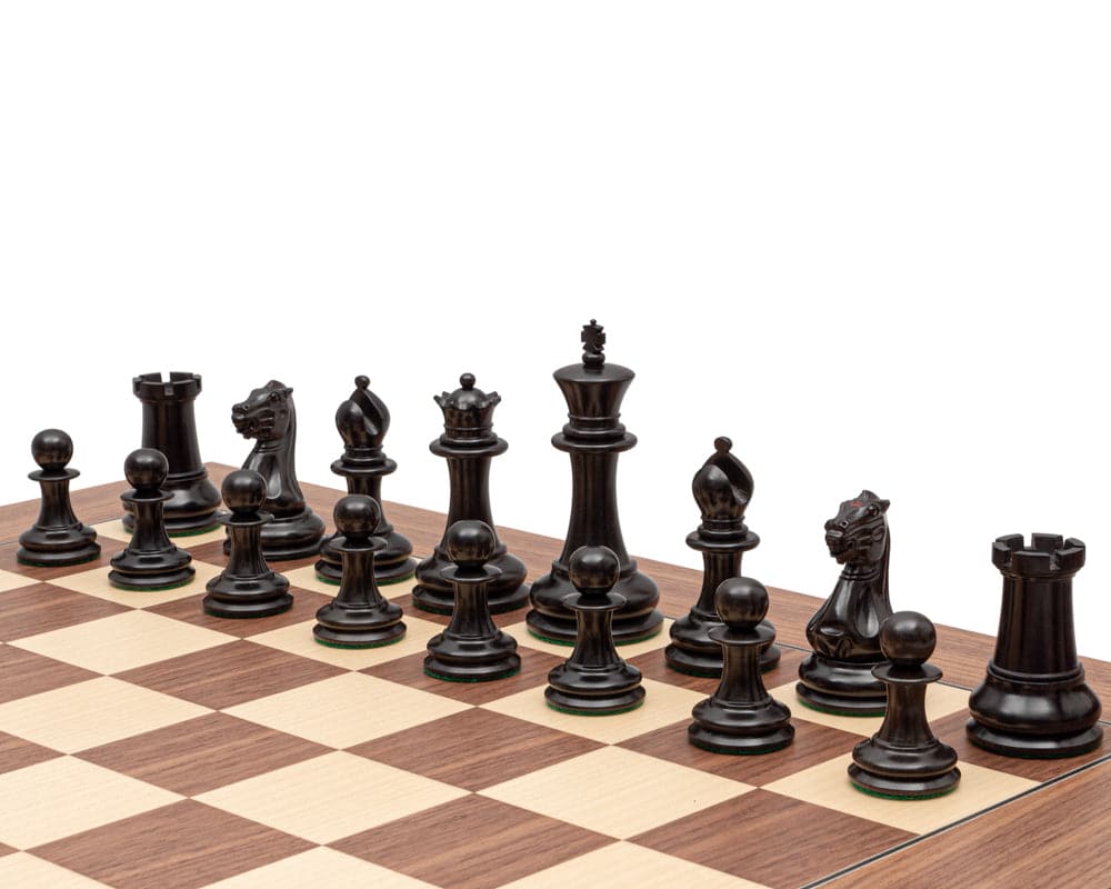 1851 Reproduction Staunton Ebony Chessmen arranged on a chessboard, featuring a 4.4-inch king and broad 2-inch bases.